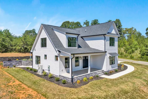 a front view of house with yard garage and outdoor seating