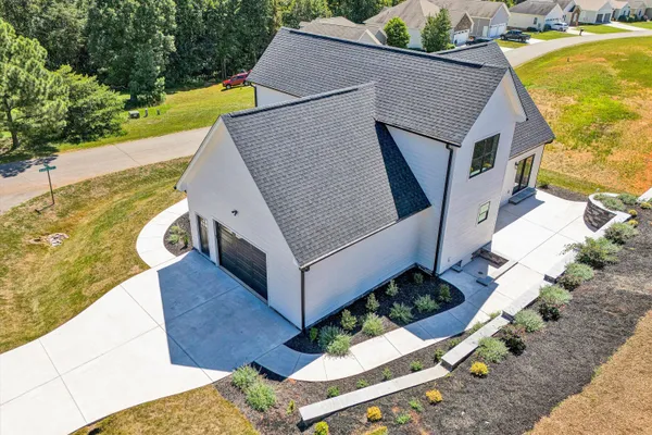 an aerial view of a house with a yard and lake view