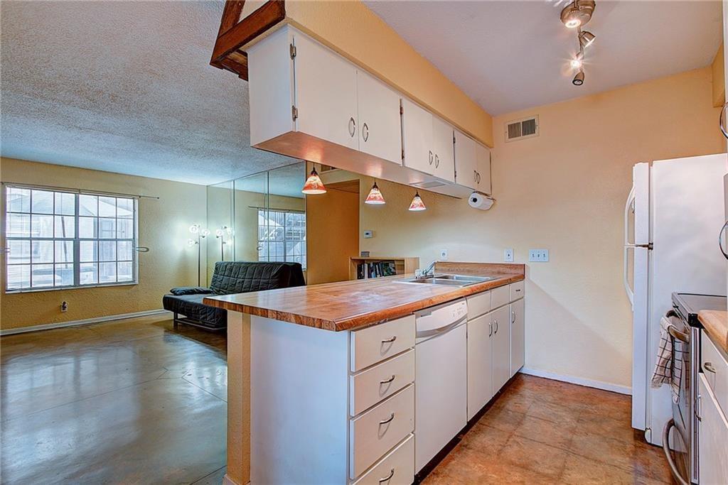 910 Duncan Lane, Unit 7 Austin, TX 78705 - Photo 7 of 20 a kitchen with a sink and a refrigerator
