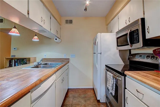 a kitchen with stainless steel appliances granite countertop a refrigerator and a stove top oven