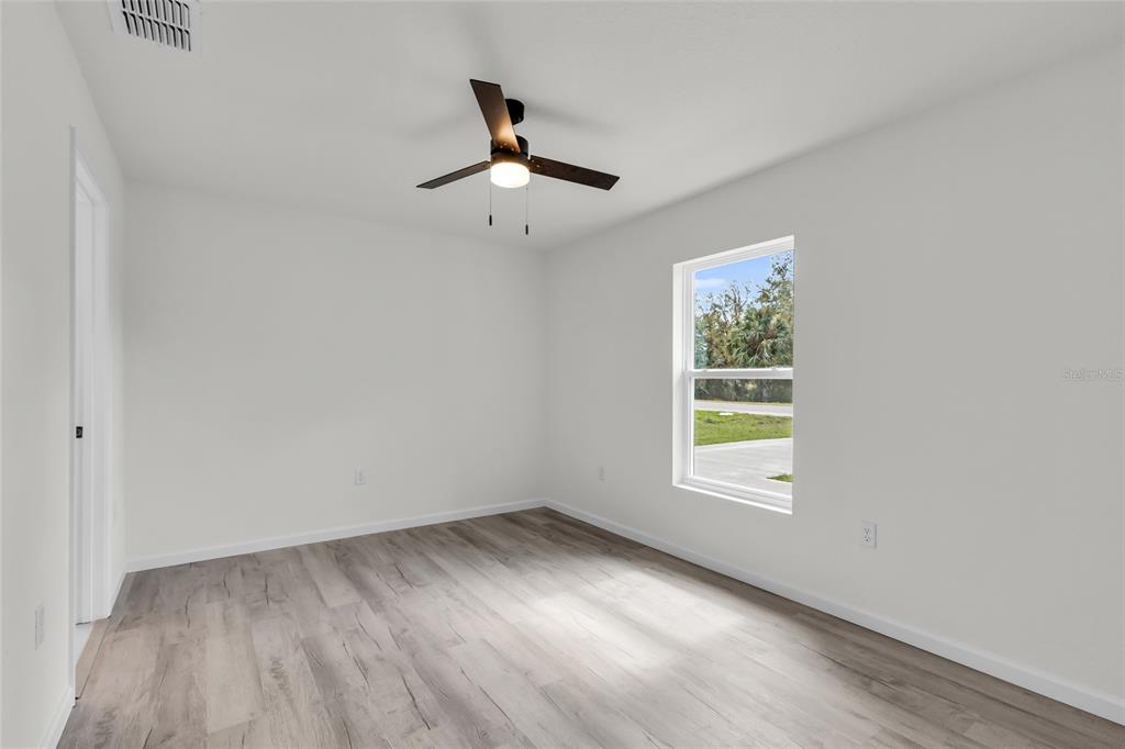 23711 Southwest Rainbow Lakes Boulevard Dunnellon, FL 34431 - Photo 16 of 27 an empty room with a window and ceiling fan