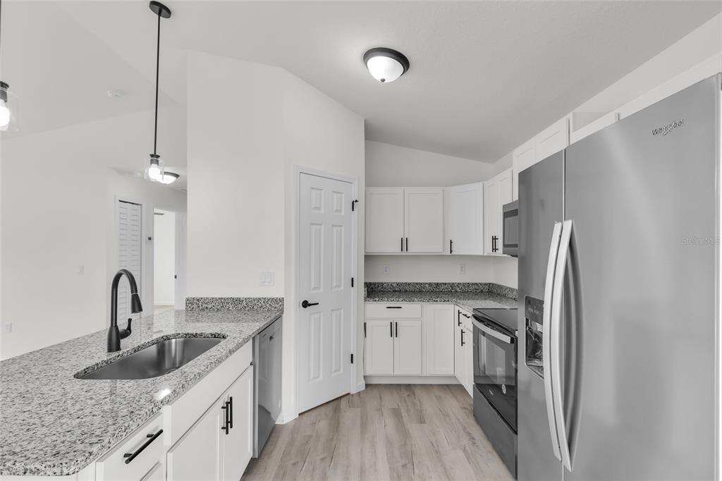 23711 Southwest Rainbow Lakes Boulevard Dunnellon, FL 34431 - Photo 9 of 27 a kitchen with stainless steel appliances granite countertop a sink stove and refrigerator