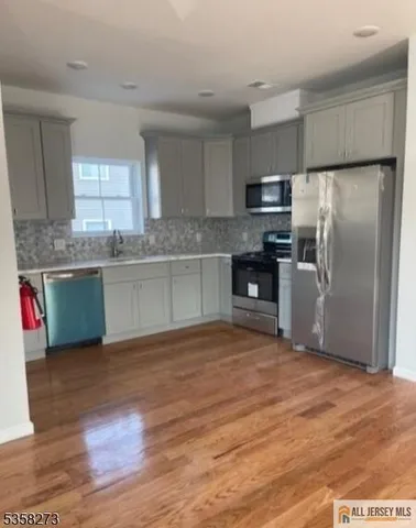 a kitchen with stainless steel appliances granite countertop a refrigerator and a stove top oven