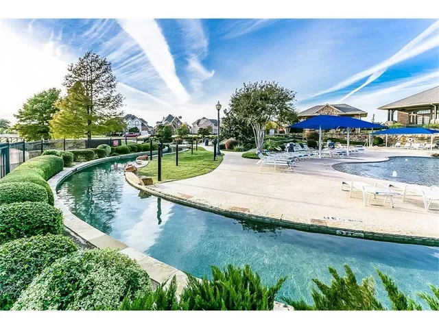 a view of a house with a big yard plants and large trees