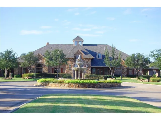 a view of swimming pool with seating area and trees in the background