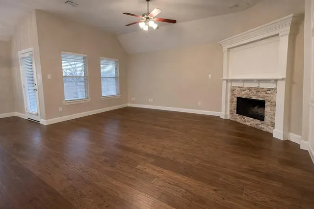 a view of a kitchen with stainless steel appliances granite countertop a sink a stove and a refrigerator