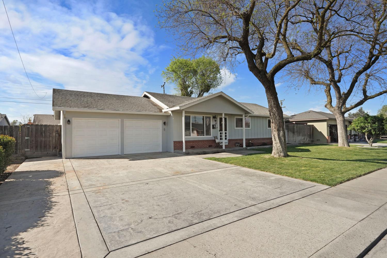 916 6th Street Ripon, CA 95366 - Photo 2 of 34 a front view of a house with a yard and garage
