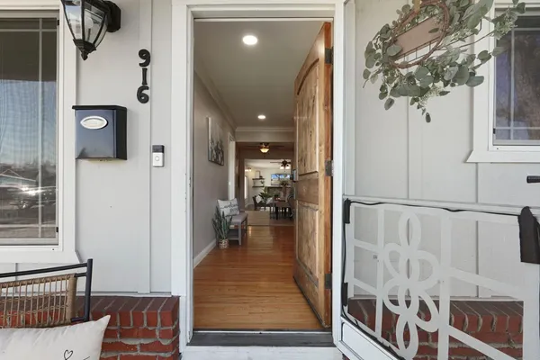 a view of a hallway with wooden floor and windows