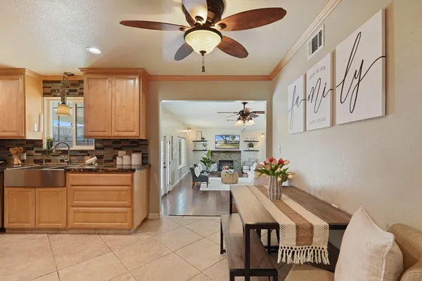 a kitchen with stainless steel appliances kitchen island granite countertop a table chairs in it and wooden floors
