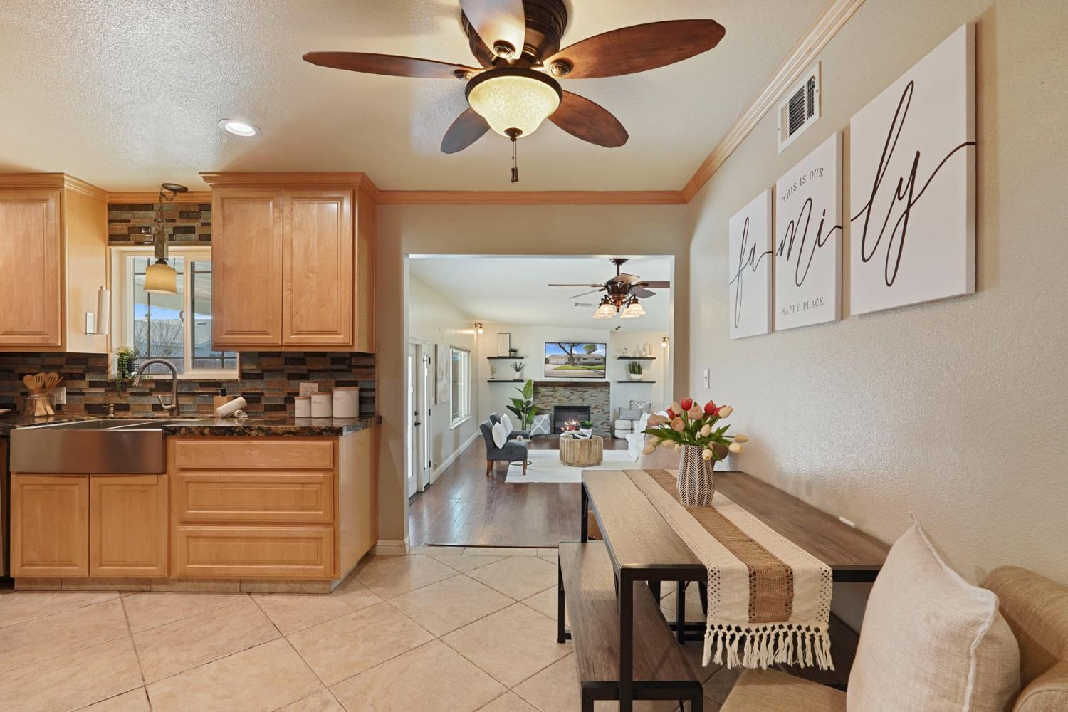 916 6th Street Ripon, CA 95366 - Photo 6 of 34 a kitchen with stainless steel appliances kitchen island granite countertop a table chairs in it and wooden floors