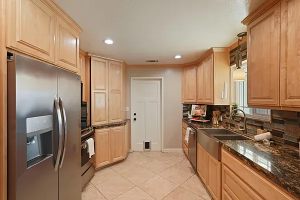 a kitchen with stainless steel appliances granite countertop a refrigerator and a stove top oven