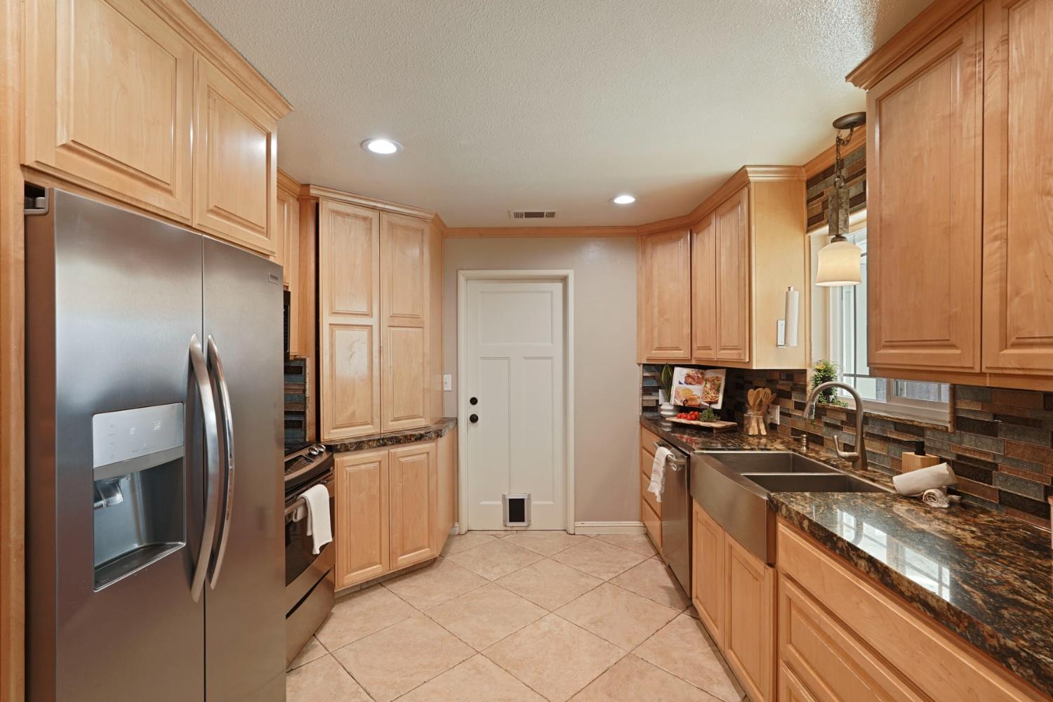 916 6th Street Ripon, CA 95366 - Photo 7 of 34 a kitchen with stainless steel appliances granite countertop a refrigerator and a stove top oven