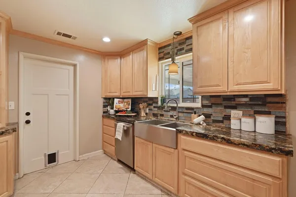 a kitchen with stainless steel appliances granite countertop a stove a sink and a refrigerator