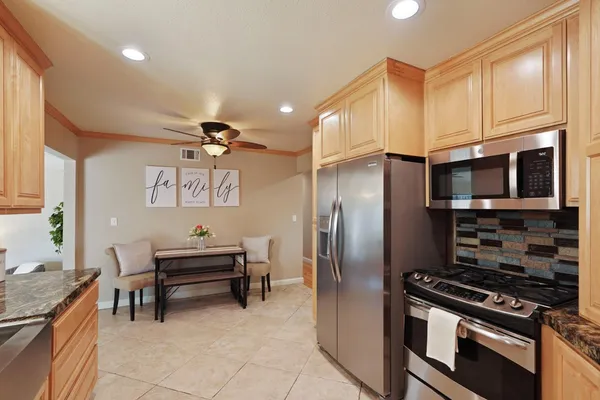 a kitchen with stainless steel appliances granite countertop a refrigerator and a stove top oven