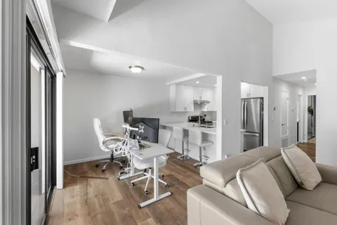 a living room with furniture and kitchen view