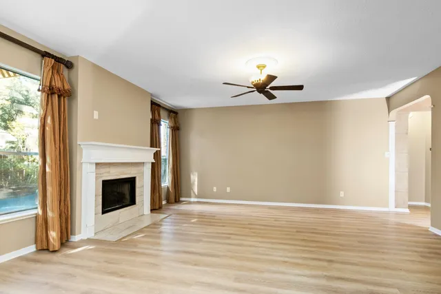 a view of a livingroom with a fireplace wooden floor and windows