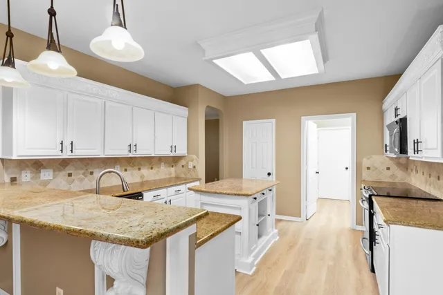 a kitchen with a sink refrigerator and cabinets