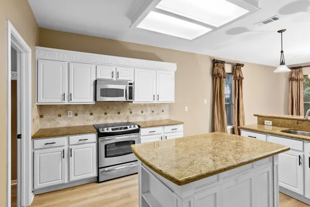 a kitchen with a stove sink and cabinets