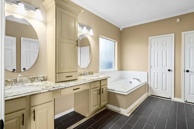 a bathroom with a double vanity sink mirror and bathtub