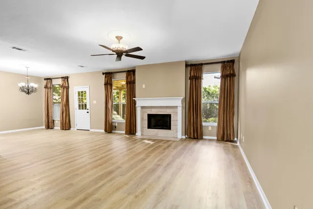 a view of an empty room with window and fire place