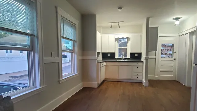 a kitchen with granite countertop white cabinets and stainless steel appliances