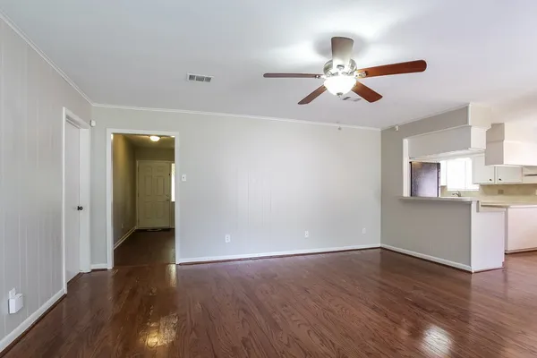 a view of empty room with wooden floor