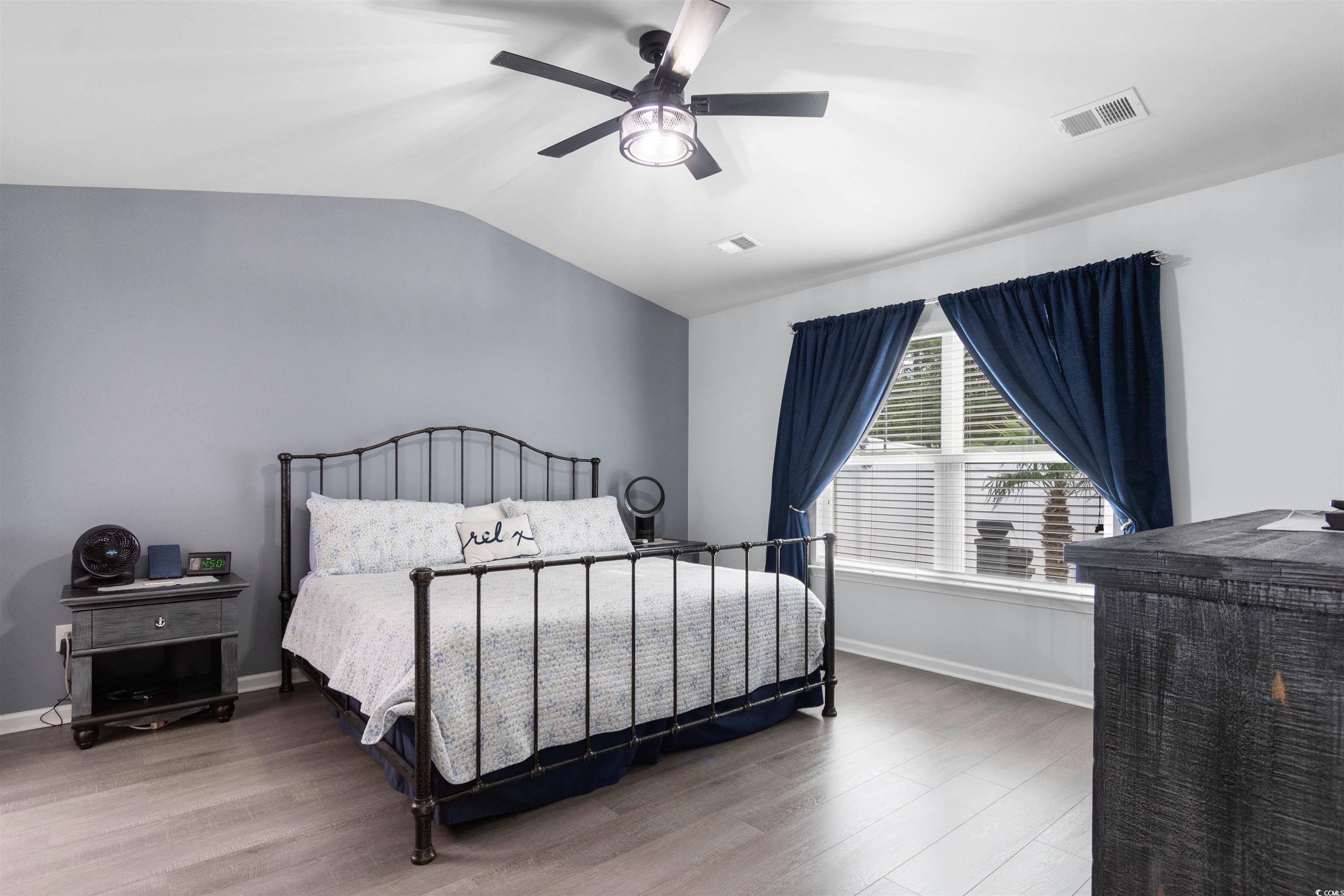 4380 Livorn Loop, Unit 4380 Myrtle Beach, SC 29579 - Photo 13 of 33 Living room with a barn door, dark wood-style floors, a ceiling fan, and high vaulted ceiling