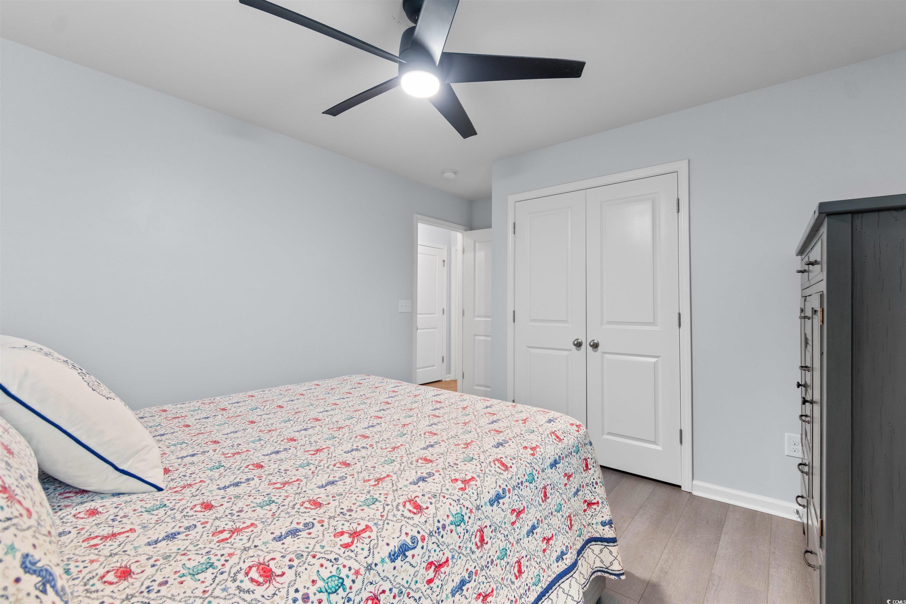 4380 Livorn Loop, Unit 4380 Myrtle Beach, SC 29579 - Photo 17 of 33 Bedroom with a barn door, dark wood-style flooring, lofted ceiling, connected bathroom, and a ceiling fan