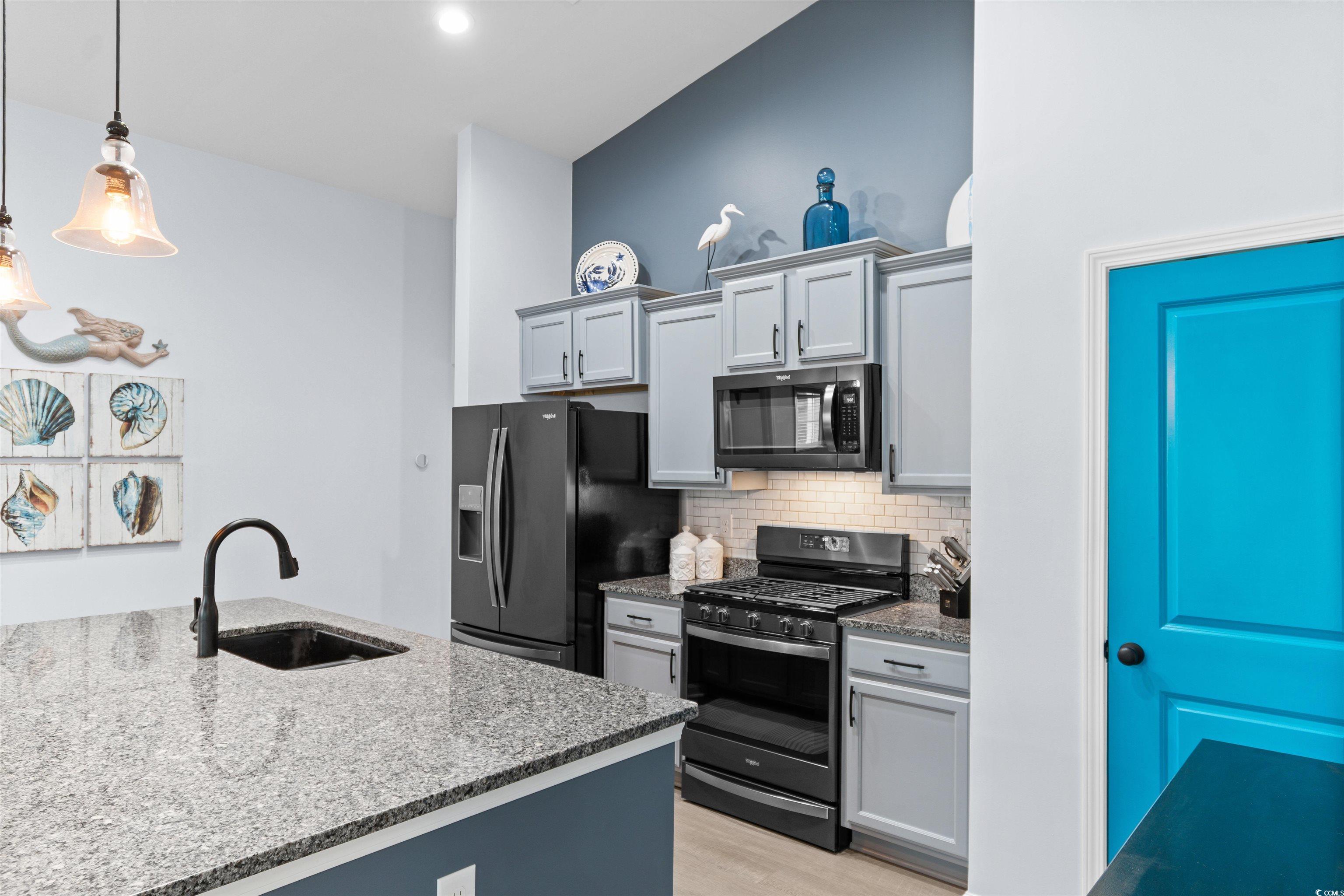 4380 Livorn Loop, Unit 4380 Myrtle Beach, SC 29579 - Photo 8 of 33 Kitchen with stainless steel gas range oven, a breakfast bar area, decorative light fixtures, light wood-style flooring, and lofted ceiling