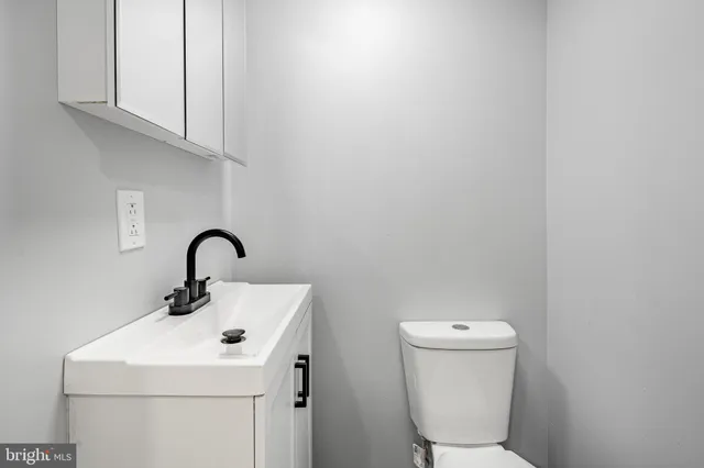 a bathroom with a sink a toilet and a mirror