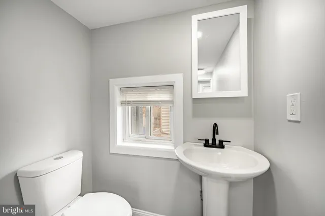 a bathroom with a sink a toilet and mirror