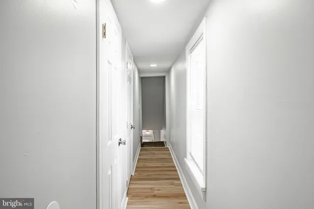 a view of a hallway with wooden floor and staircase