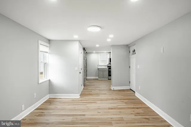 a view of a big room with wooden floor and windows