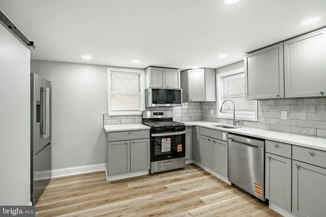a kitchen with cabinets stainless steel appliances and a counter space