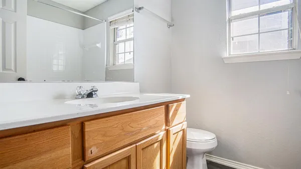a bathroom with a granite countertop sink toilet and a mirror