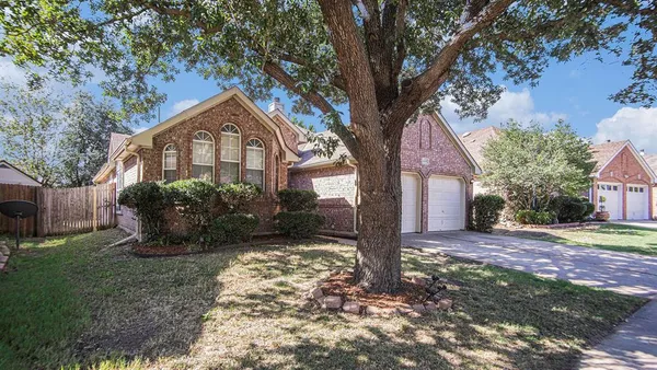 a view of a house with a tree in the yard