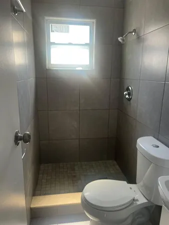 a bathroom with a toilet and a shower
