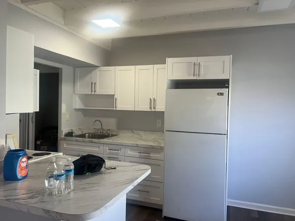 a kitchen with a refrigerator a stove a sink and white cabinets