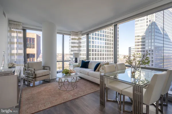 a living room with furniture and floor to ceiling windows