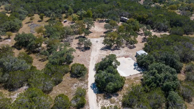 an aerial view of residential houses with outdoor space and trees