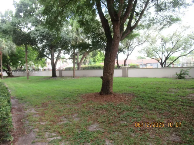 a view of a patio with table and chairs potted plants with floor to ceiling window