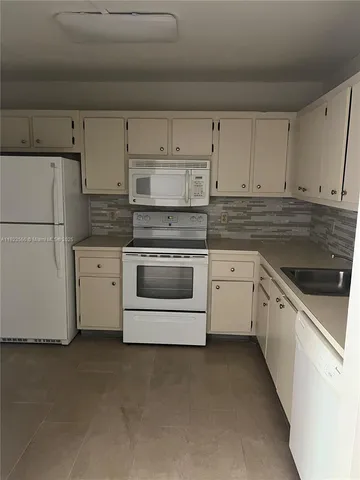 a kitchen with cabinets stainless steel appliances and sink