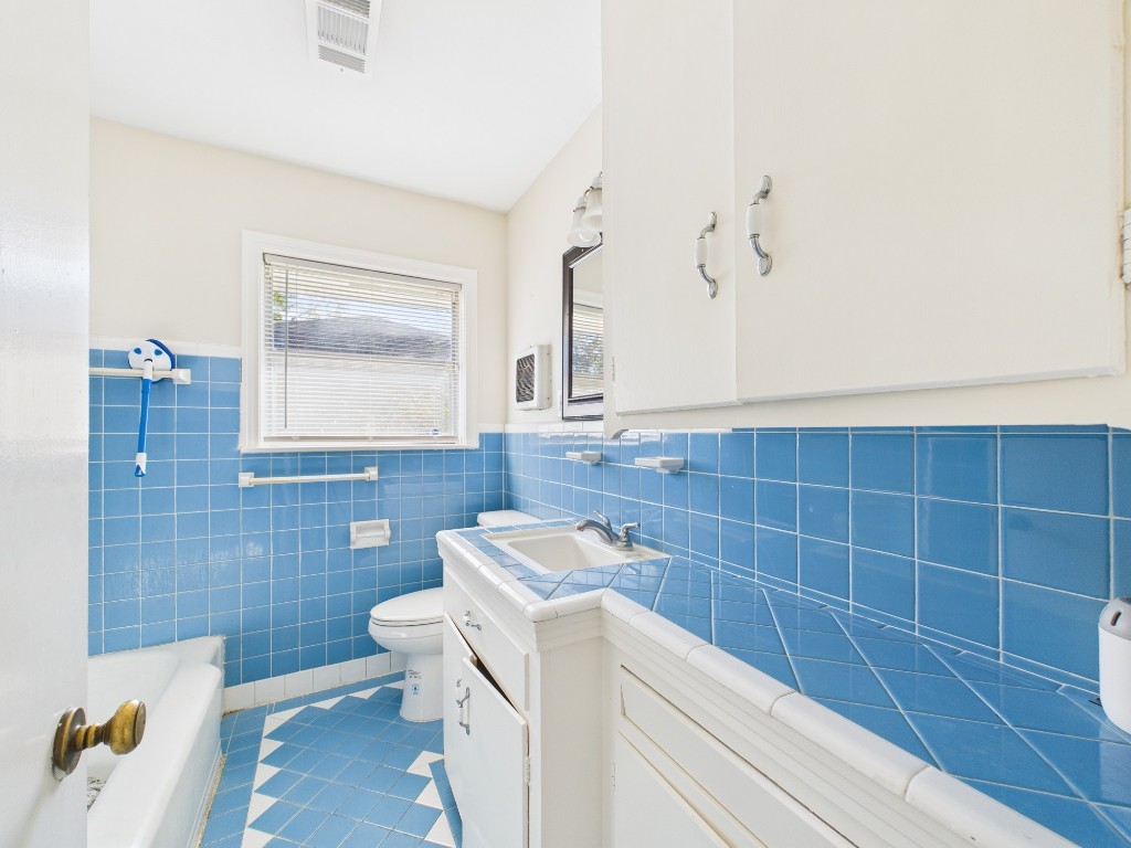 3035 Guese Road Houston, TX 77018 - Photo 13 of 20 a bathroom with a sink a toilet and mirror
