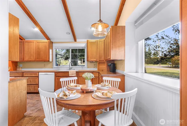 a dining room with furniture and a floor to ceiling window