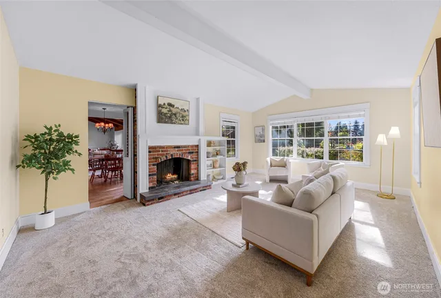 a living room with furniture a fireplace and a large window
