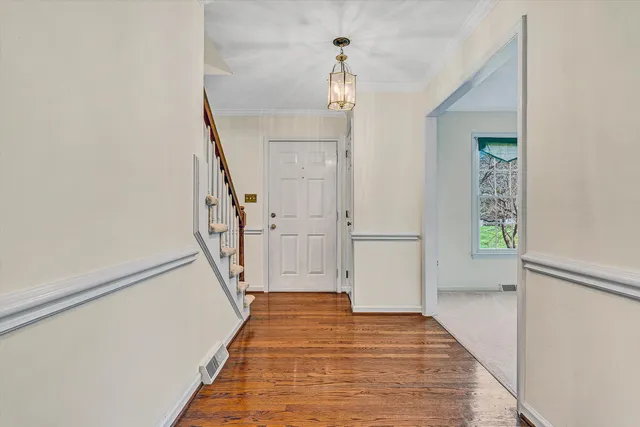 a view of a hallway with wooden floor and staircase