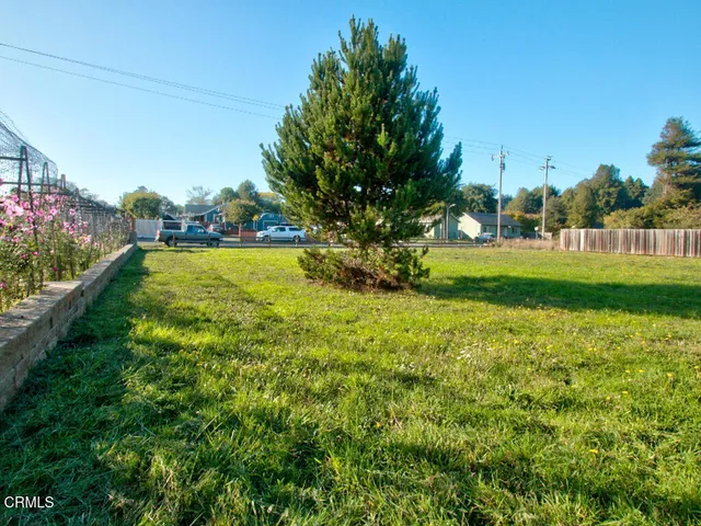 a view of a swimming pool with lawn chairs under an umbrella