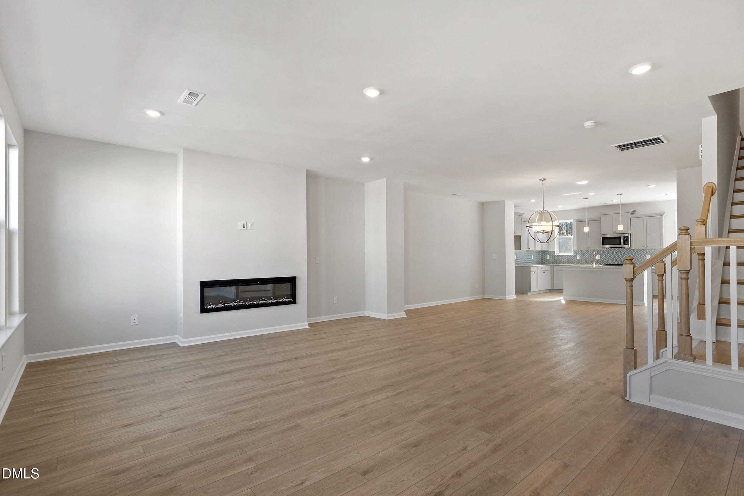 367 Chesapeake Commons Street, Unit 115 Garner, NC 27529 - Photo 8 of 43 a view of an empty room with wooden floor