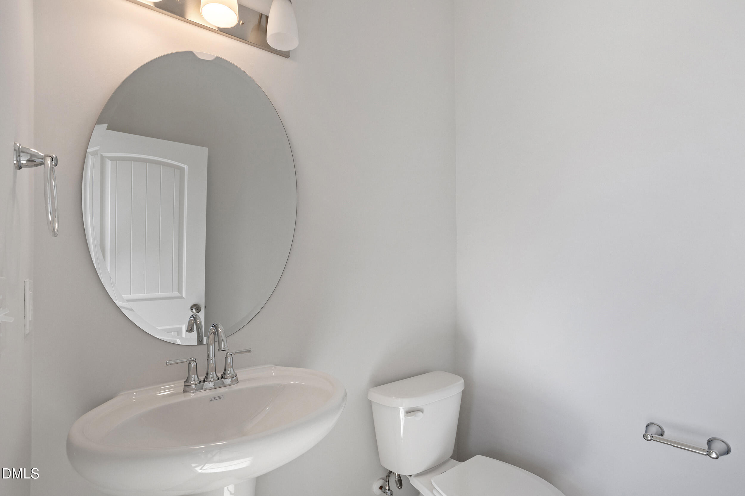 367 Chesapeake Commons Street, Unit 115 Garner, NC 27529 - Photo 12 of 43 a bathroom with a toilet a sink and mirror