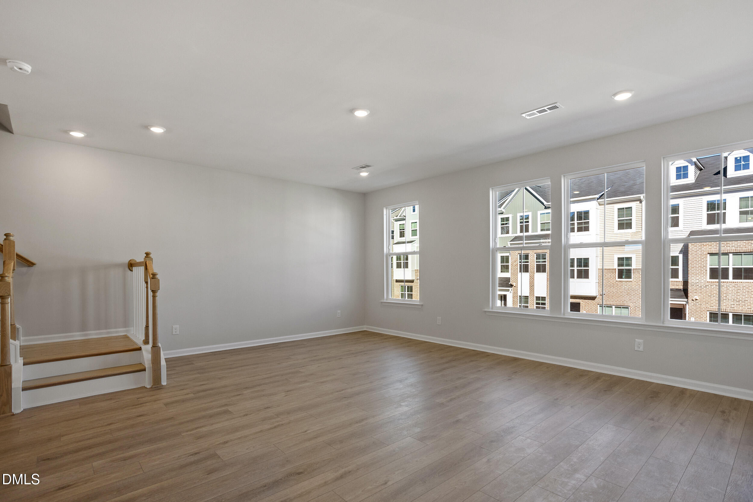 367 Chesapeake Commons Street, Unit 115 Garner, NC 27529 - Photo 7 of 43 a view of an empty room with wooden floor and a window